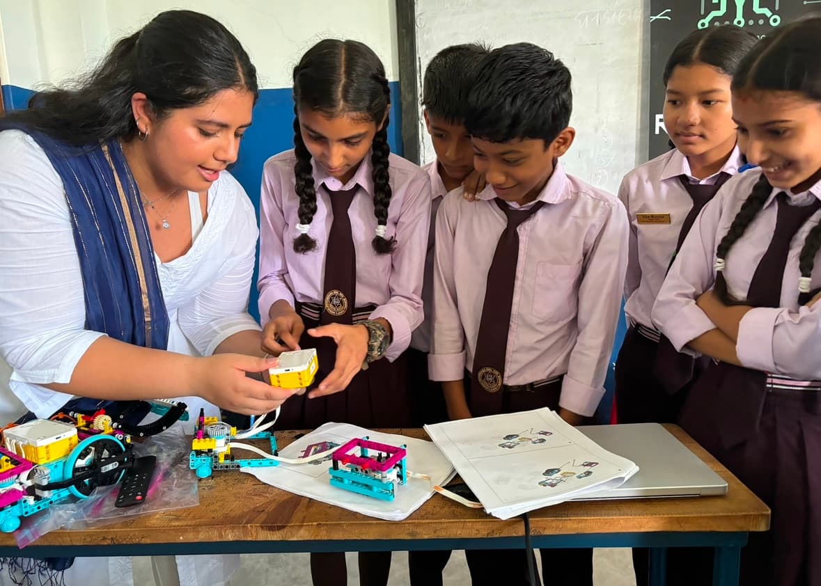 Navya walking students through robotics kit components during a classroom session